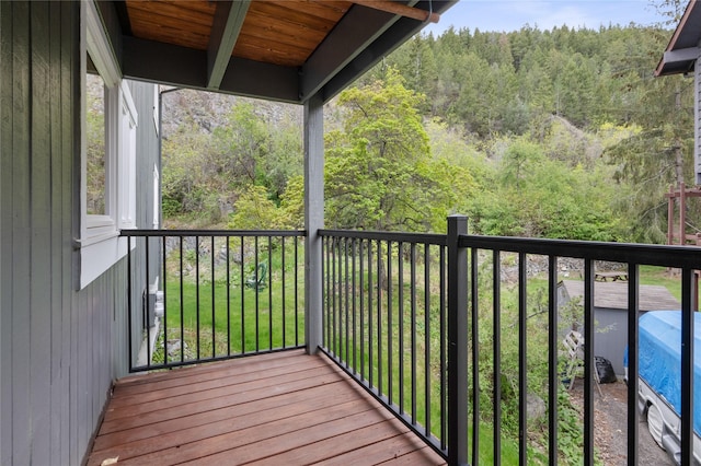 wooden terrace featuring a view of trees
