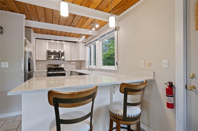 kitchen with appliances with stainless steel finishes, wooden ceiling, a sink, a peninsula, and beamed ceiling