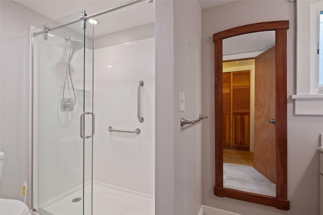 full bath with toilet and a stall shower