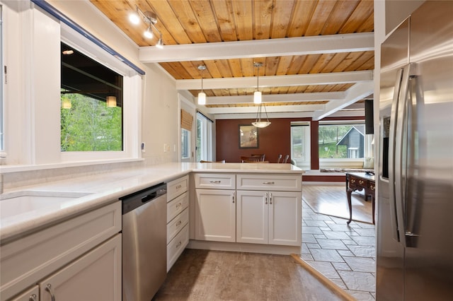 kitchen with appliances with stainless steel finishes, stone tile flooring, wooden ceiling, beam ceiling, and light countertops