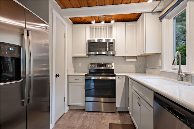 kitchen featuring stainless steel appliances, wooden ceiling, a sink, beamed ceiling, and decorative backsplash