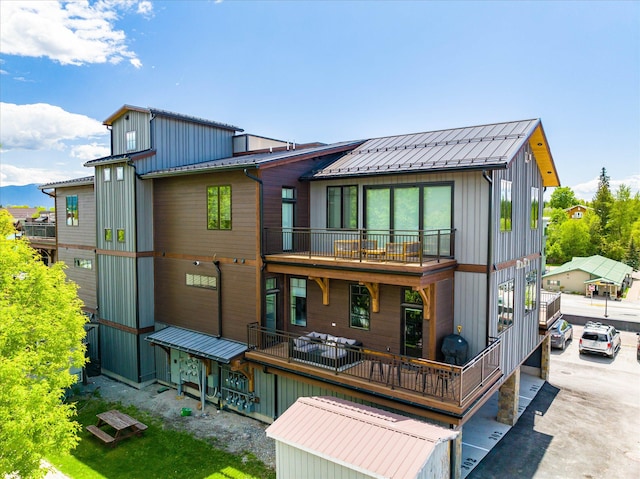 rear view of house featuring a balcony and board and batten siding