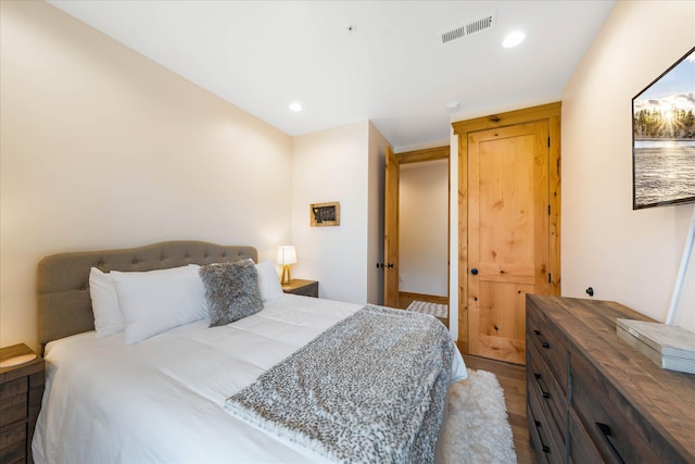 bedroom with wood finished floors and recessed lighting