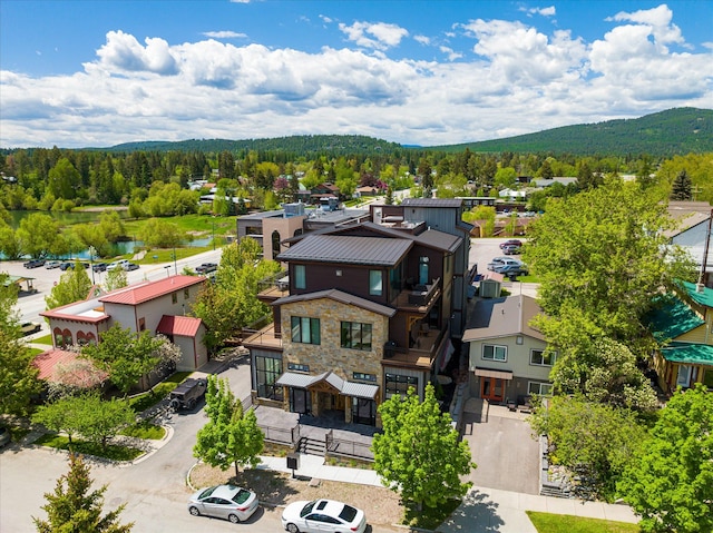 aerial view of residential area featuring a mountain backdrop and a forest