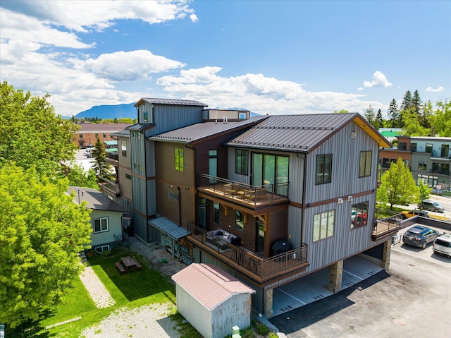 back of property featuring a standing seam roof, metal roof, a balcony, a mountain view, and board and batten siding