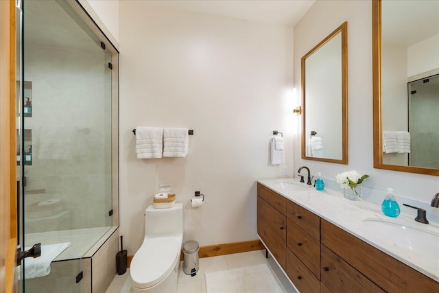 bathroom featuring toilet, a stall shower, tile patterned floors, double vanity, and baseboards