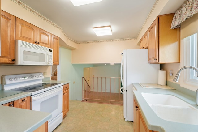 kitchen with white appliances, a sink, light countertops, and light flooring