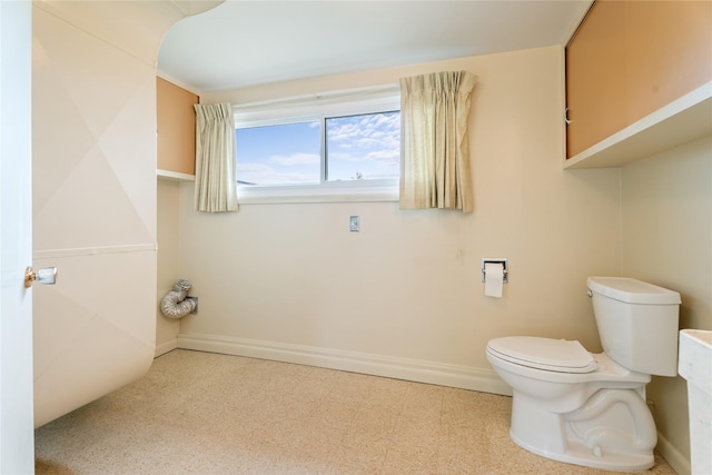 bathroom featuring tile patterned floors, baseboards, and toilet
