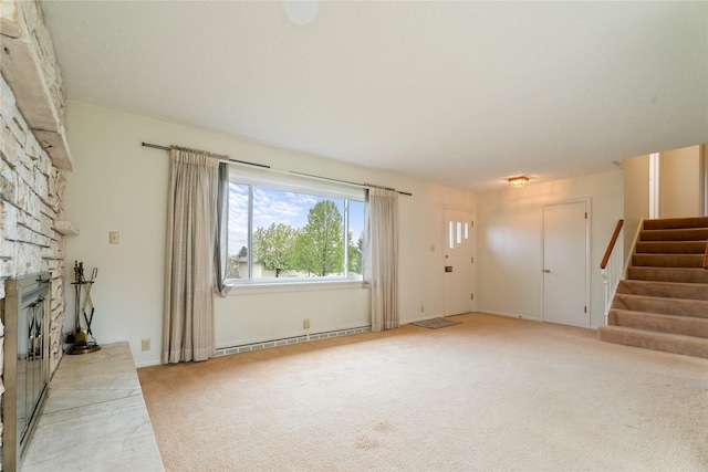 unfurnished living room featuring baseboard heating, carpet floors, stairs, and a stone fireplace