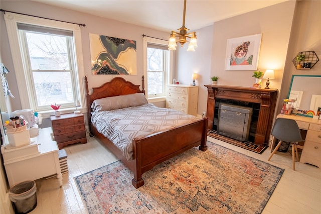 bedroom with wood finished floors and a fireplace with flush hearth