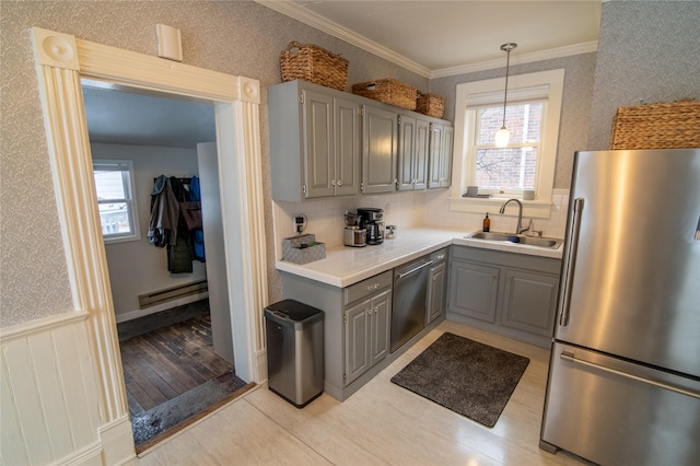 kitchen featuring stainless steel appliances, gray cabinetry, a sink, a baseboard heating unit, and light wood-style flooring