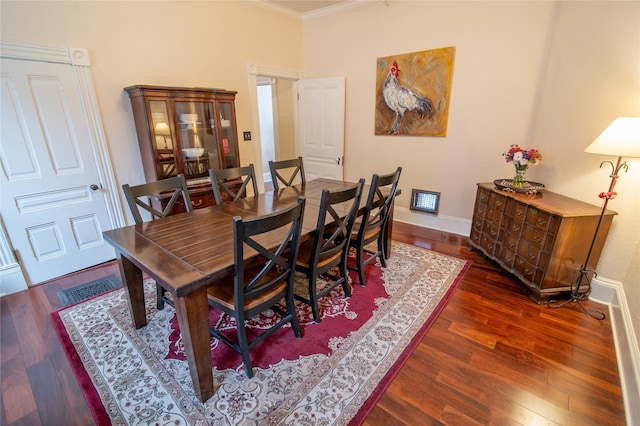 dining area featuring crown molding, wood finished floors, and baseboards