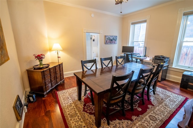 dining area with wood finished floors, crown molding, and baseboards