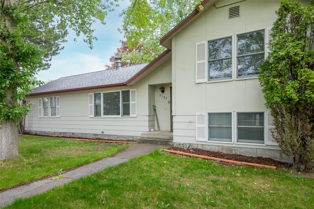 split level home featuring a front yard and a shingled roof