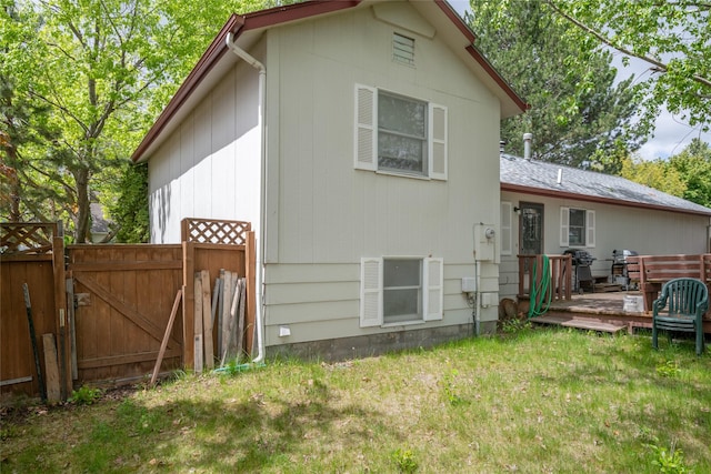 rear view of property with a wooden deck and a gate