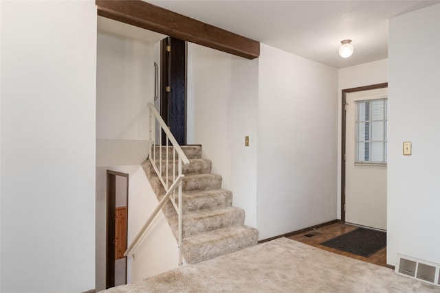 entrance foyer featuring carpet and stairs