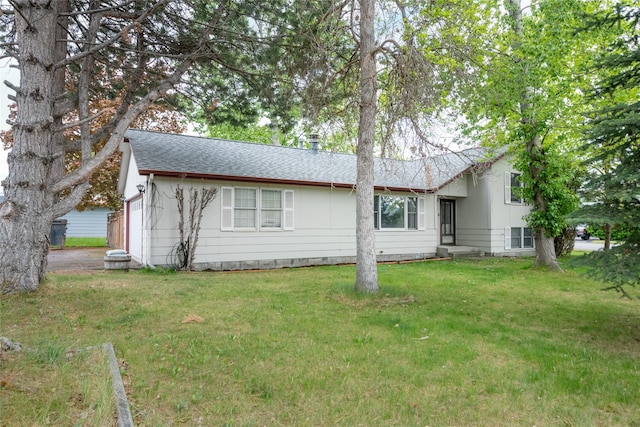 view of front of house featuring a shingled roof, a front lawn, and a garage
