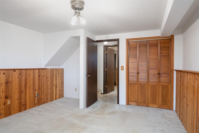 additional living space featuring carpet and wood walls