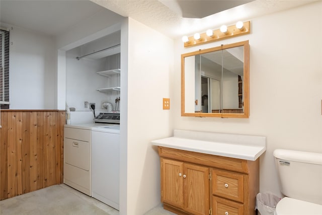 bathroom with washing machine and clothes dryer, vanity, and toilet