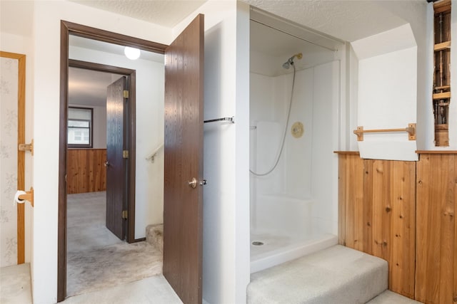bathroom featuring a shower and wood walls