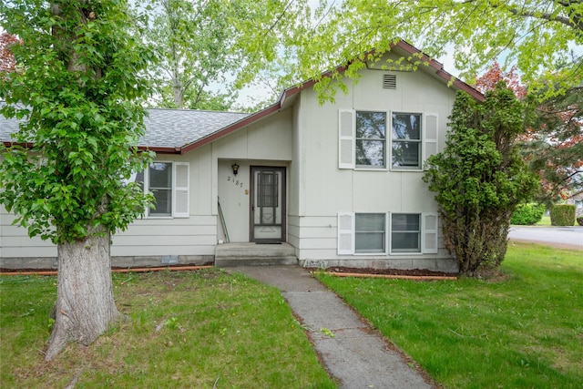 split level home featuring a front yard and a shingled roof