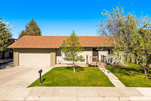 ranch-style home featuring driveway, an attached garage, and a front yard