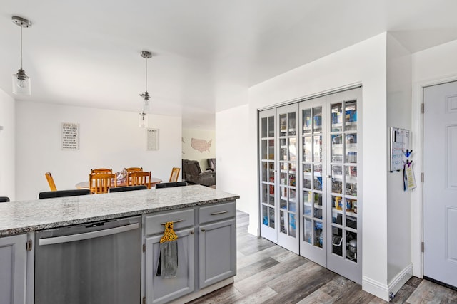 kitchen featuring dishwasher, gray cabinetry, wood finished floors, and hanging light fixtures