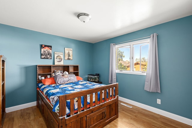 bedroom featuring wood finished floors and baseboards