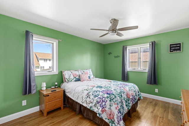 bedroom featuring wood finished floors, baseboards, and a ceiling fan