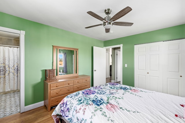 bedroom with wood finished floors, a closet, baseboards, and a ceiling fan