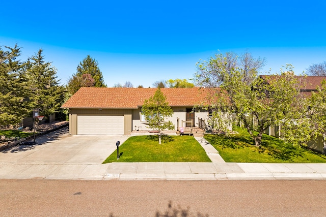 view of front facade with concrete driveway, an attached garage, and a front lawn