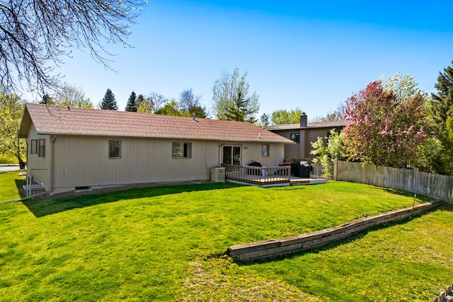 back of house with a wooden deck, central AC unit, and a chimney