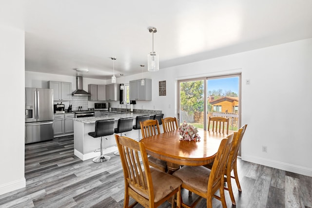 dining room featuring dark wood-style flooring and baseboards