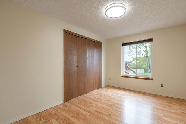 4 Rocky Mountain Dr, Whitehall, MT 59759 - unfurnished bedroom with light wood-type flooring, a textured ceiling, a closet, and baseboards