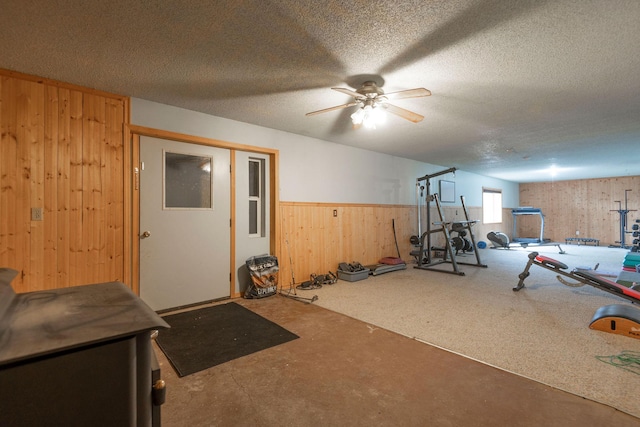 4 Rocky Mountain Dr, Whitehall, MT 59759 - exercise area featuring wooden walls, ceiling fan, a textured ceiling, and a wainscoted wall