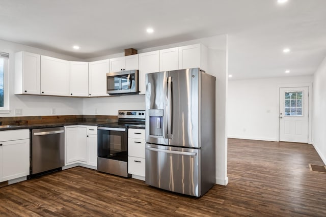 135 Meadow Ln, Victor, MT 59875 - kitchen featuring stainless steel appliances, dark countertops, dark wood-type flooring, white cabinetry, and recessed lighting