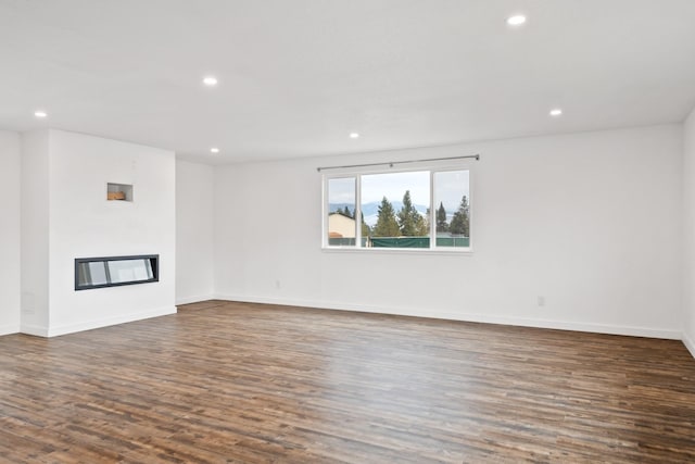 135 Meadow Ln, Victor, MT 59875 - unfurnished living room with recessed lighting, dark wood finished floors, a glass covered fireplace, and baseboards