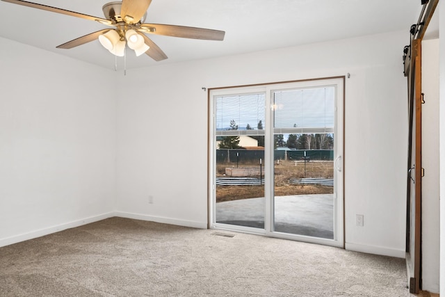135 Meadow Ln, Victor, MT 59875 - spare room with a barn door, carpet, ceiling fan, and baseboards