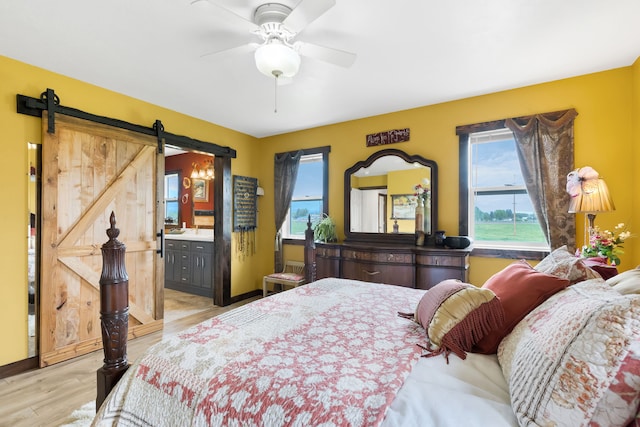 551 Fox Meadow Ln, Hamilton, MT 59840 - bedroom with a barn door, light wood-type flooring, ensuite bathroom, and ceiling fan