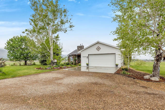 551 Fox Meadow Ln, Hamilton, MT 59840 - view of property exterior featuring driveway, a yard, an attached garage, and a chimney
