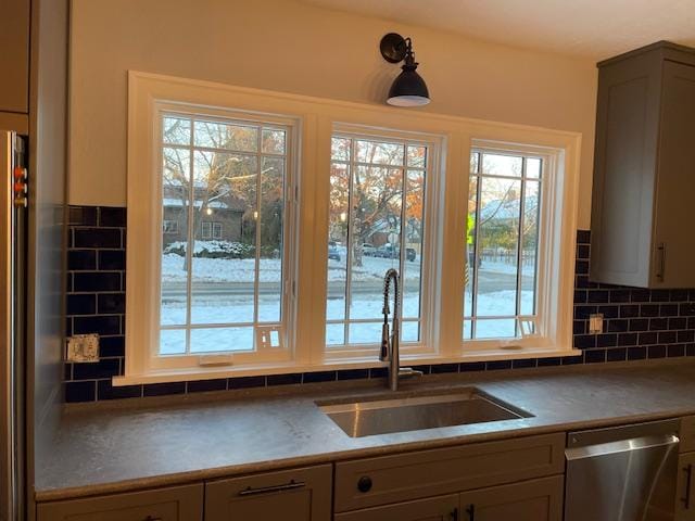 339 E Beckwith Ave, Missoula, MT 59801 - kitchen featuring stainless steel dishwasher, a sink, plenty of natural light, and backsplash