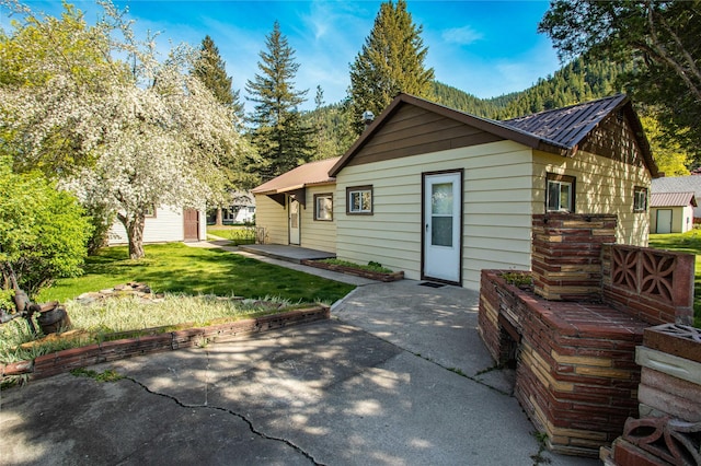 10225 Shady Ln, Bonner, MT 59823 - rear view of house with a patio, metal roof, and a yard