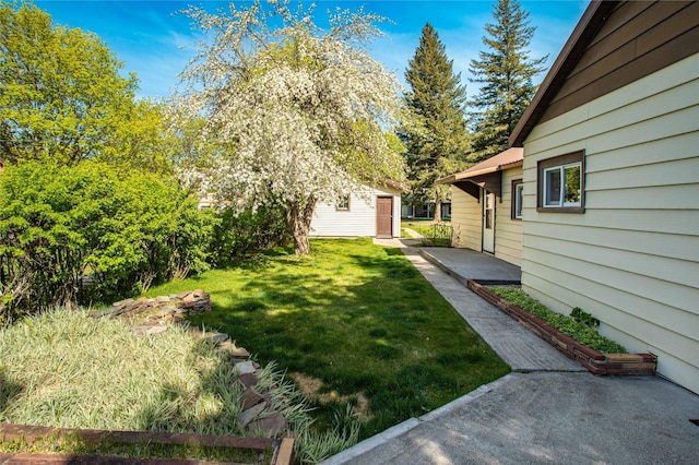 10225 Shady Ln, Bonner, MT 59823 - view of green lawn featuring an outdoor structure and a patio