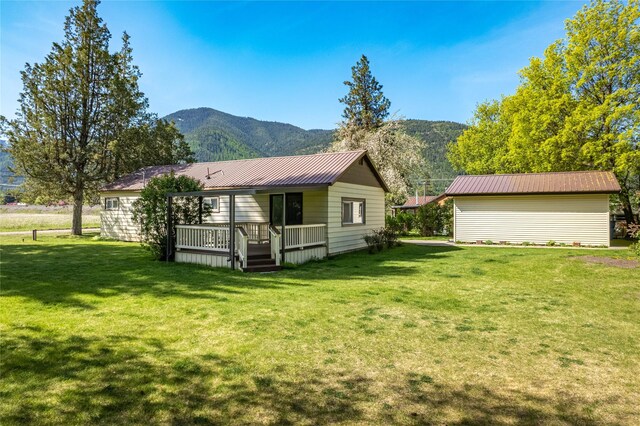 10225 Shady Ln, Bonner, MT 59823 - back of house with a yard, metal roof, and a deck with mountain view