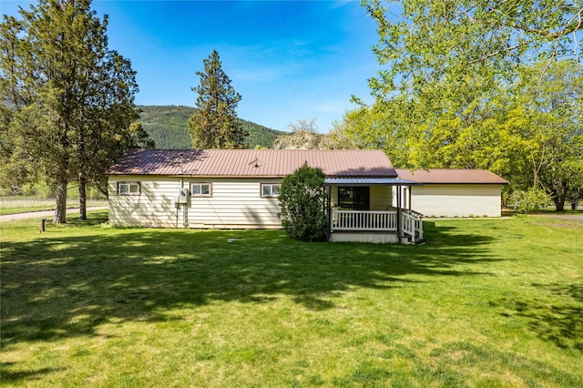10225 Shady Ln, Bonner, MT 59823 - rear view of house with a yard, covered porch, and metal roof