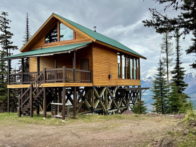 back of house with metal roof and stairs