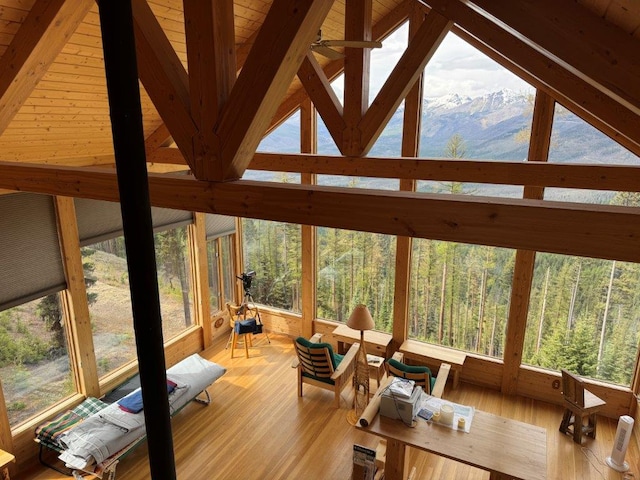 sunroom / solarium featuring hardwood / wood-style flooring, a mountain view, and healthy amount of natural light