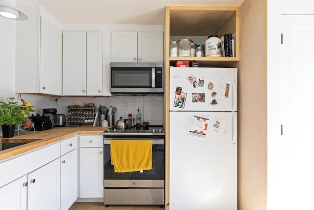2112 W Central Ave, Missoula, MT 59801 - kitchen with stainless steel appliances, decorative backsplash, and white cabinets