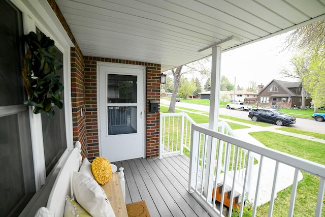 deck featuring a porch, a residential view, and a yard