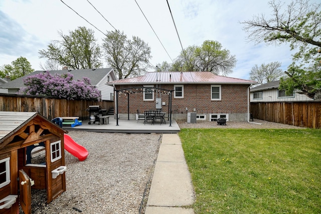 rear view of property featuring brick siding, metal roof, outdoor dining area, and cooling unit